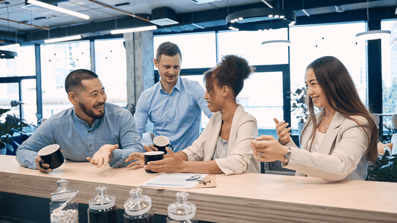 Cheerful corporate employees communicating at coffee break